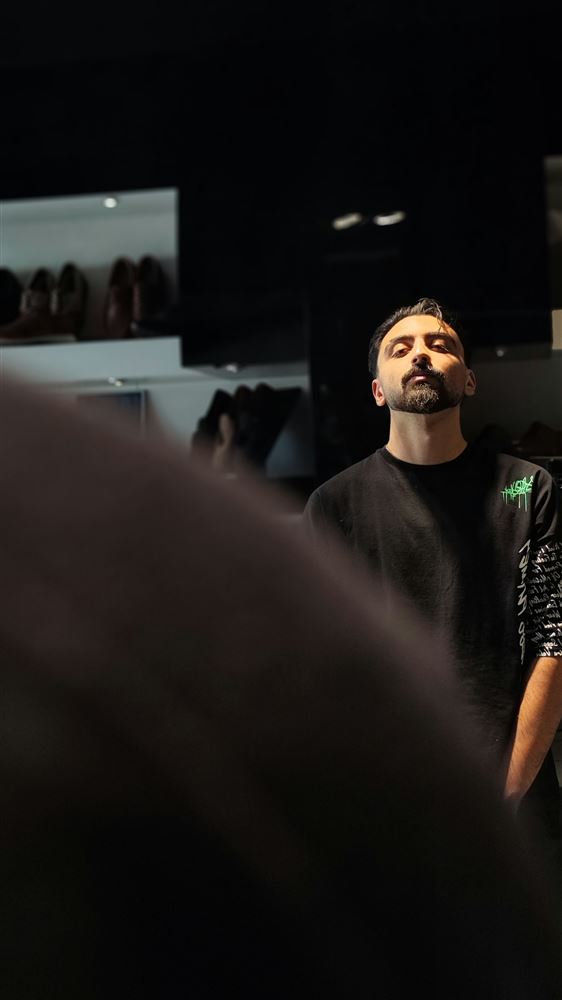 Man in a black tee with his head tilted back