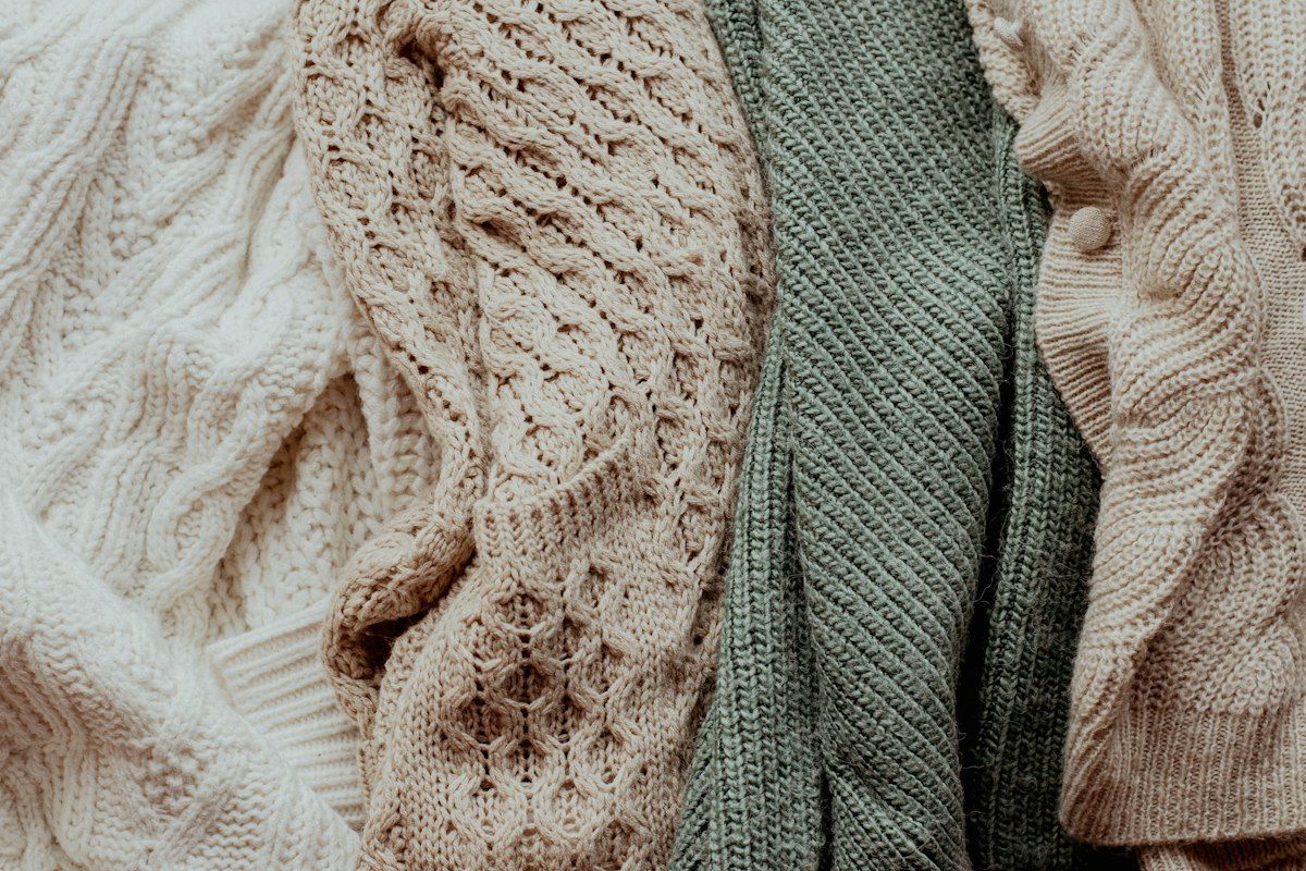 Close-up of cable and rib knits in cream and sage